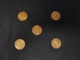 six gold coins are arranged in a circle on a black surface