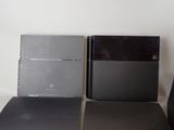 two black and silver video game consoles next to each other