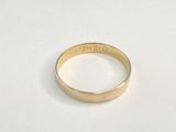 gros plan d'une bague en or sur une surface blanche