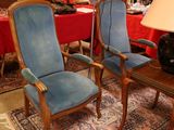two blue chairs in a room with a red wall