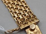 an image of a gold chain bracelet with a button on it