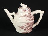 brown and white teapot with a bird on it on a black background