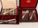 silverware in a case with a red velvet lining on a white surface