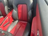 une photo d'une voiture avec des sièges en cuir rouge et noir
