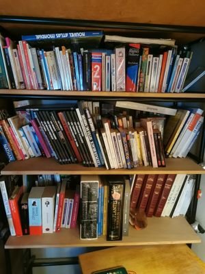 une bibliothèque remplie de livres et un téléphone portable posé sur une table