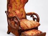 une image représentant une chaise dont l'assise et le repose-pieds sont recouverts d'un tissu à motifs floraux