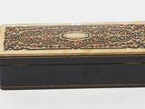 a small black and gold box with a floral design on it