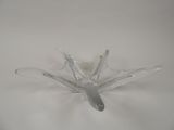 a clear glass flower shaped object on a white surface
