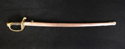 un gros plan d'une épée posée sur une surface noire
