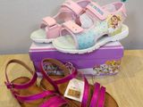 two pairs of girls ' sandals are sitting on a table