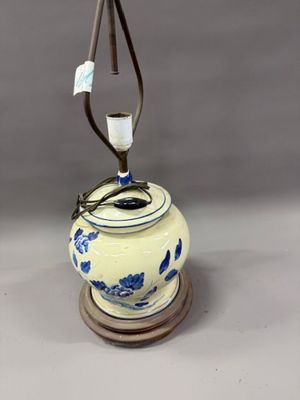 une image représentant un vase bleu et blanc sur lequel est posée une lampe