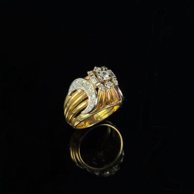 a gold and diamond ring on a black surface