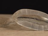 a clear plastic object on a table with a black background