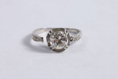 a close up of a diamond ring on a white surface