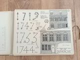 an open book with drawings of a building and numbers on it