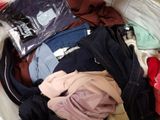 a pile of clothes that is sitting on a bed