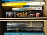 de nombreux livres dans une boîte en carton posée sur une étagère
