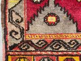 a close up of a red and yellow rug on a white surface