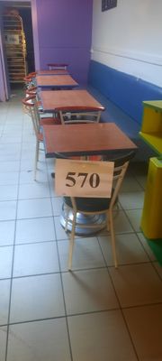 de nombreuses tables et chaises alignées dans une pièce