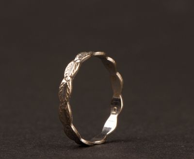 gros plan d'une bague en argent sur une surface noire