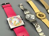 three different colored watches sitting next to each other on a table