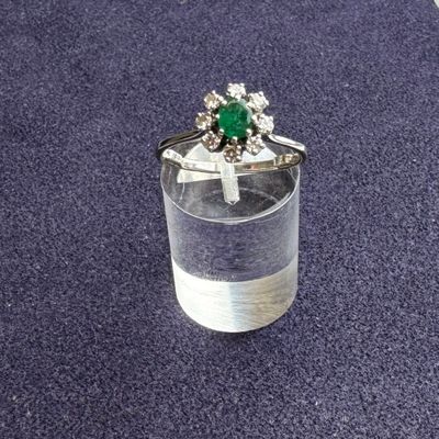 une bague sertie d'une pierre verte posée sur un verre