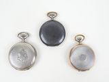 three different types of pocket watches on a white surface