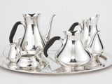 un plateau en argent avec trois pichets en argent et un plateau en argent muni d'une poignée noire