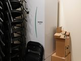 de nombreuses chaises et un réfrigérateur dans une pièce remplie de cartons