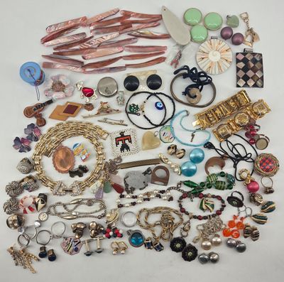 a pile of assorted jewelry on a white surface