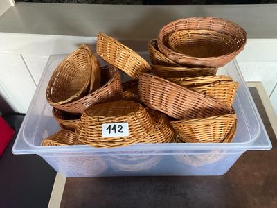 un bac en plastique rempli de paniers en osier posé sur un comptoir