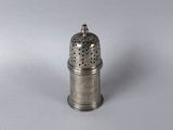 a small silver pepper shaker on a white surface