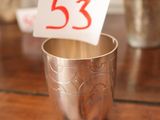 une coupe en argent sur laquelle figure un chiffre rouge, posée sur une table