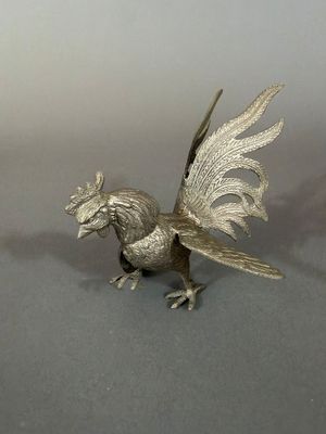 a silver colored bird figurine on a table