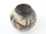 a vase with a painting on it on a white surface
