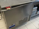 plan de travail en acier inoxydable dans une cuisine professionnelle avec un sol carrelé