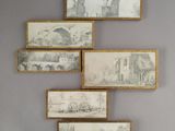 several framed drawings hang on the wall of a room