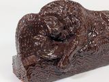 a chocolate sculpture of a dog laying on a rock