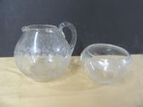 a glass pitcher and a glass bowl on a table