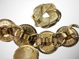 a close up of a gold bracelet and brooch
