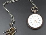 a silver pocket watch with a chain attached to it