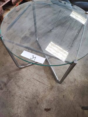 une table en verre avec un plateau en verre, posée à même le sol