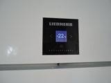 a white refrigerator with a digital clock on the door