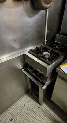 a kitchen with a stove and pots hanging on the wall