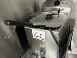 stainless steel counter top with a fryer and a sink in a kitchen