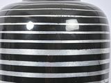 a black and white striped vase sitting on a table