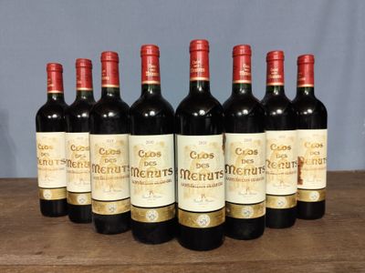 six bottles of red wine are lined up on a wooden table