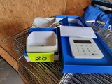 a calculator sitting on a wire shelf next to a blue box