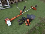 une photo d'une tondeuse à gazon avec des outils posés sur l'herbe