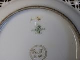 a close up of a white plate with a gold border